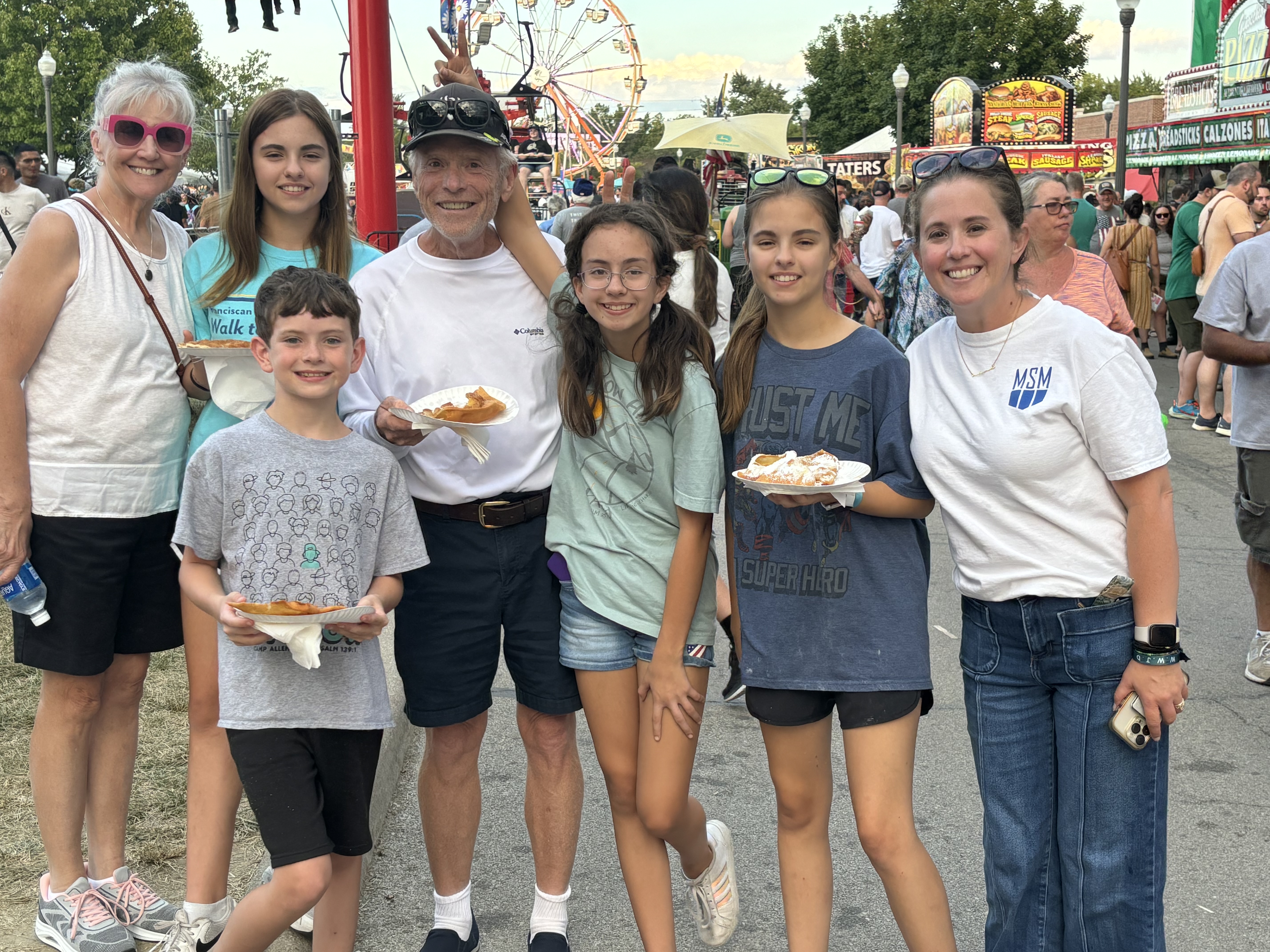 Bob Massie with family at the state fair, the central family group gathered together with the fair in the background.